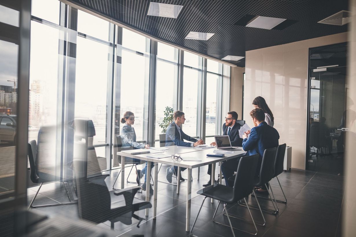 A group of people are sitting around a table in a conference room.