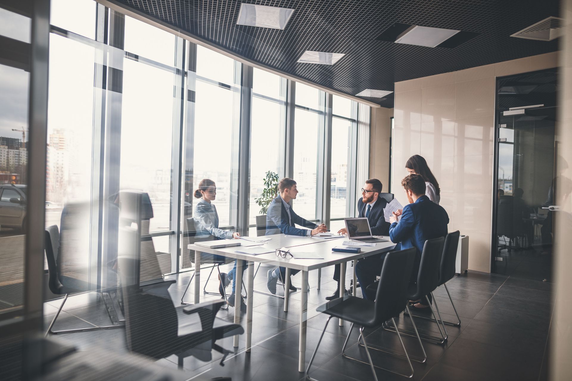 A group of people are sitting around a table in a conference room.