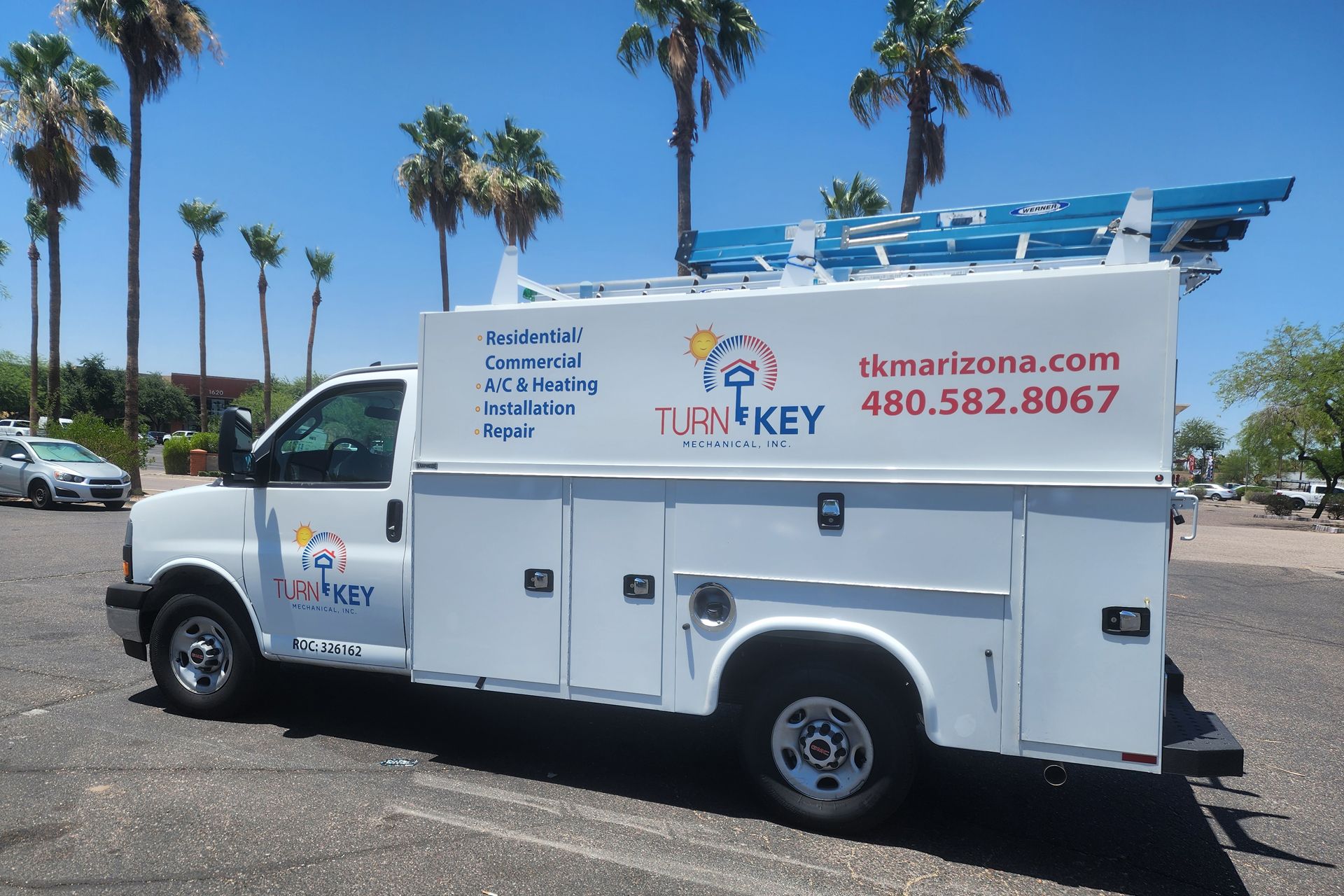 A white utility truck is parked in a parking lot
