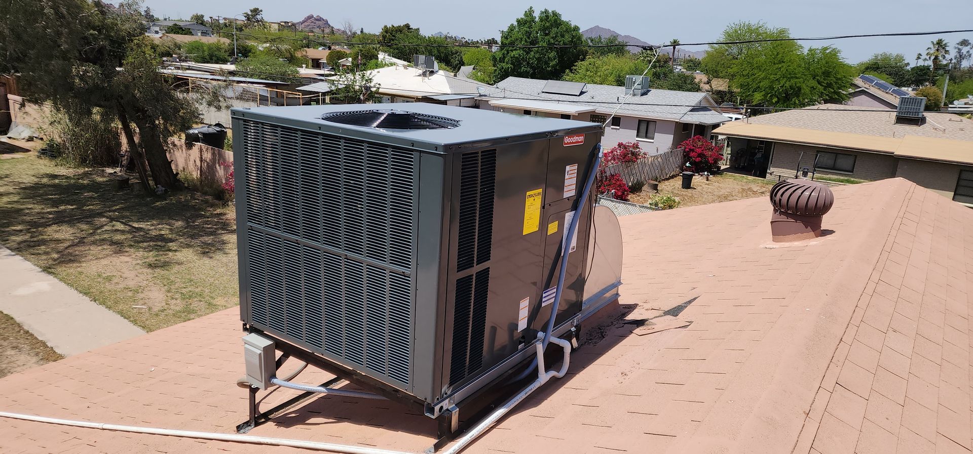 A large air conditioner is sitting on top of a roof.