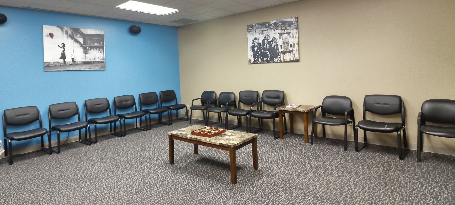 A waiting room with rows of chairs and a coffee table