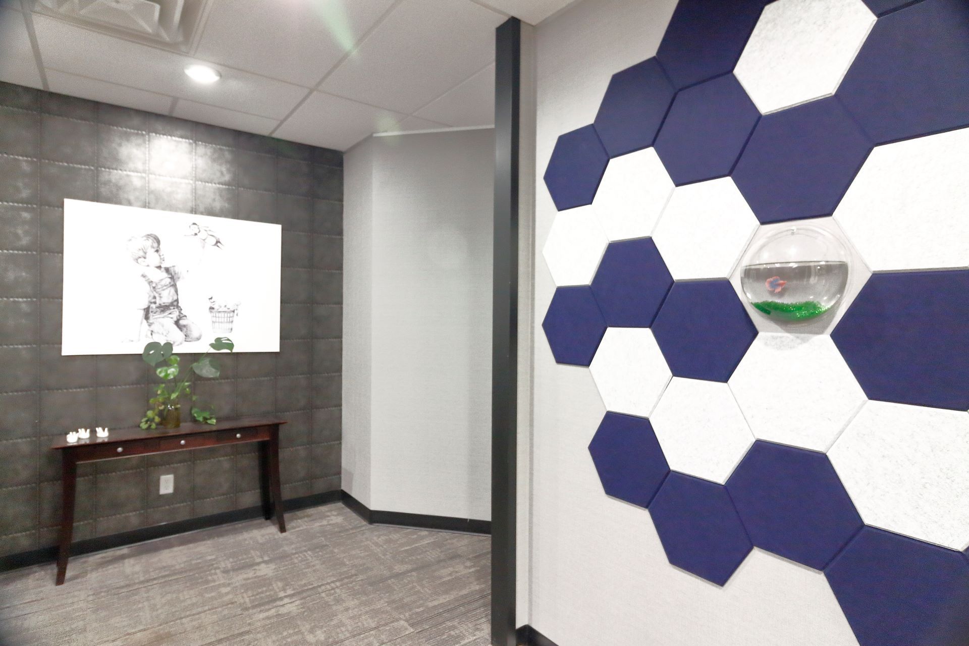 A hallway with a table and a painting on the wall