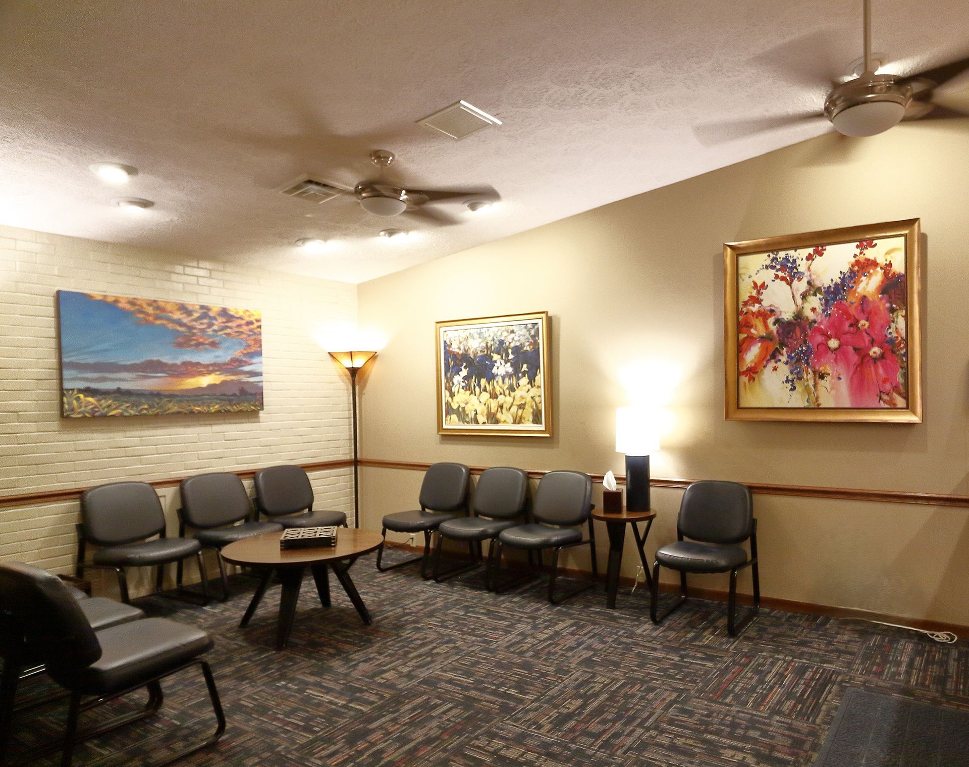 A waiting room in Southpark Psychology, 2100 facility with chairs, a table, and a ceiling fan.