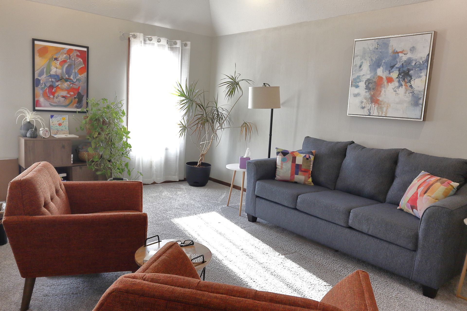 A living room with a couch and two chairs. - Tara Smith