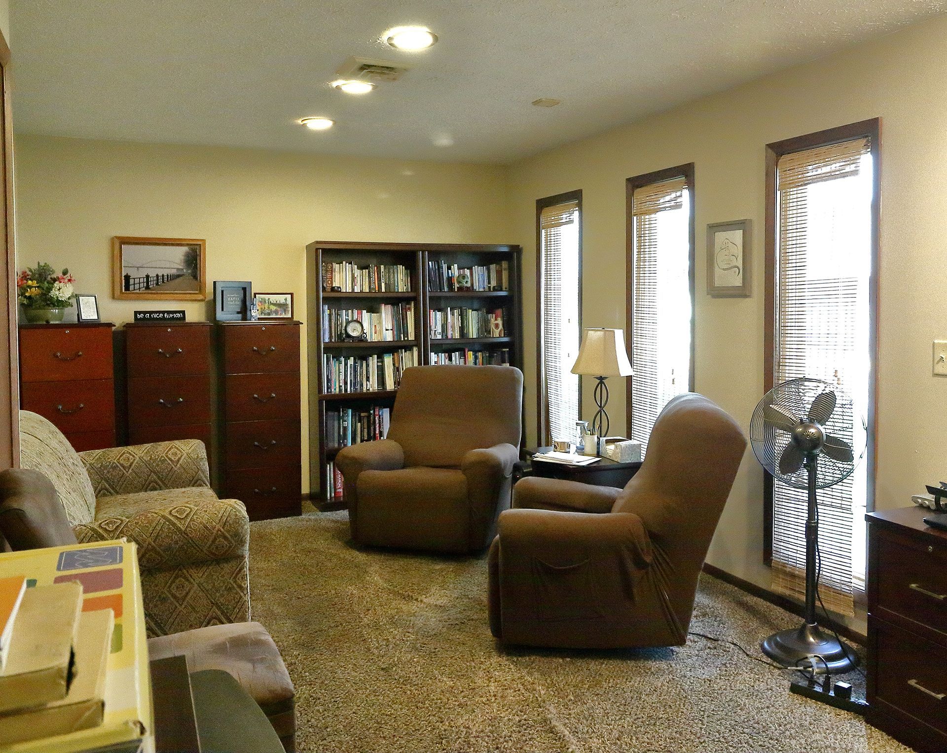 A living room with two chairs a couch and a bookshelf. - Dr. Ludwig