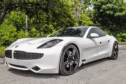 White sports coupe parked on a tree-lined road, angled front-left view