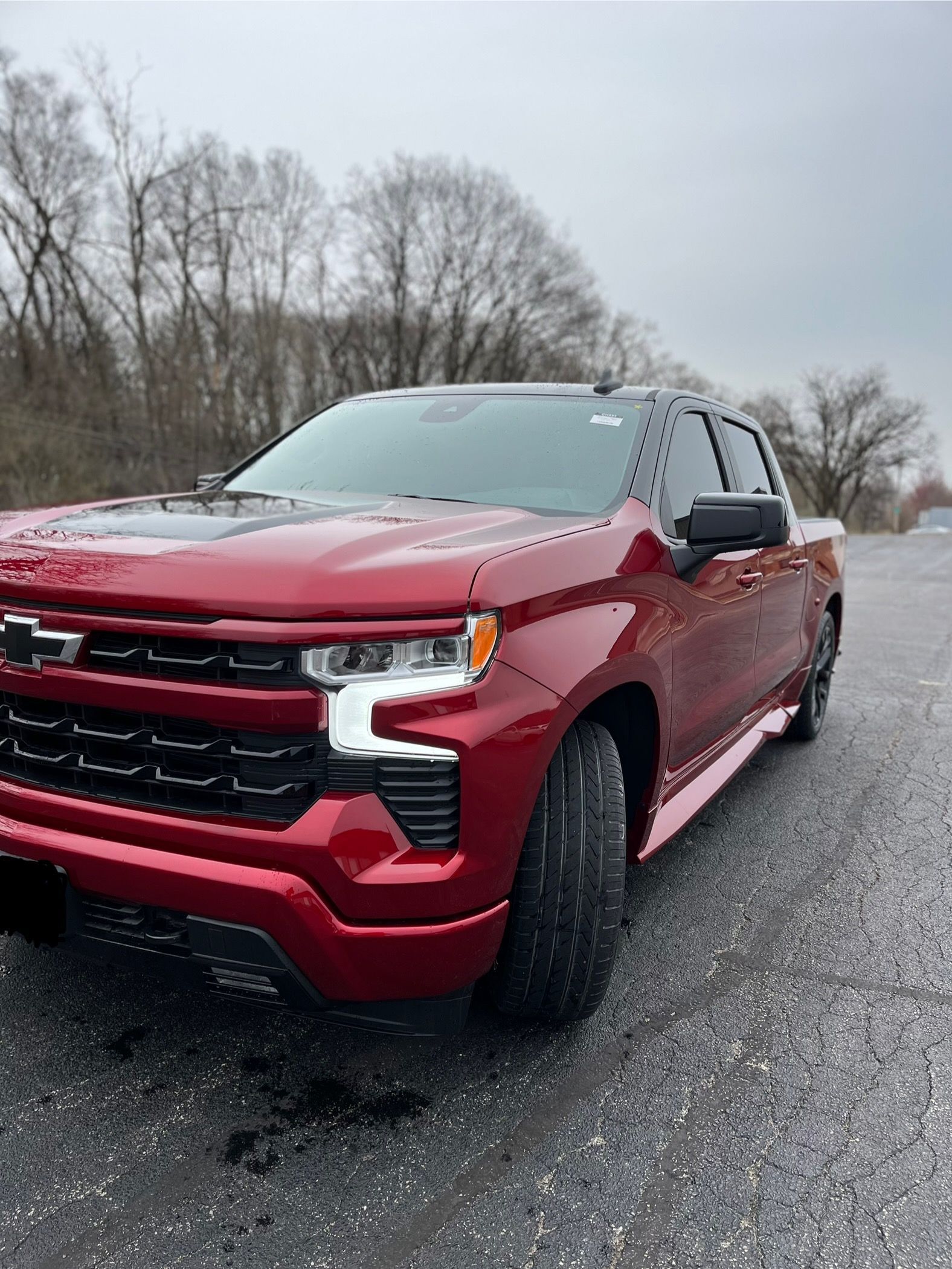 Red pickup truck parked on a wet road
