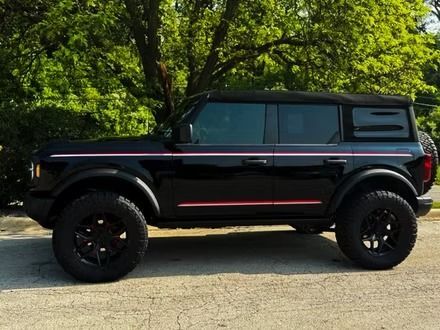 Black lifted off-road SUV parked on a road with trees in the background