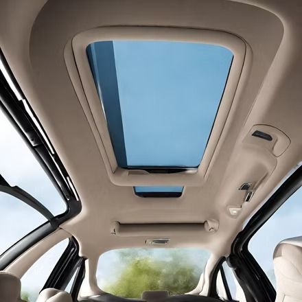 Interior view of a car roof with a sunroof and blue sky visible through it