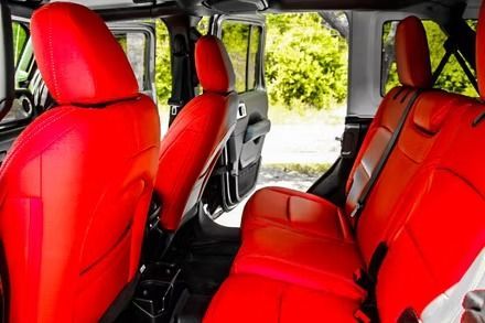 Red car interior with bright red seats and black trim viewed from the back seat