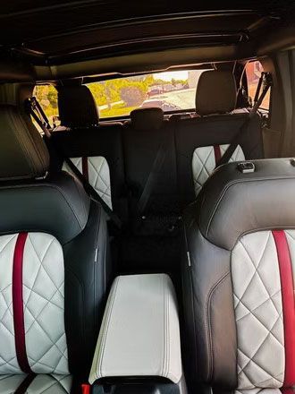 Interior of a car with black and white quilted seats and a light center console.