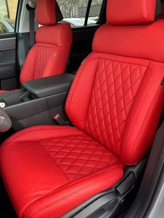 Red quilted leather car seats and center console inside a vehicle interior