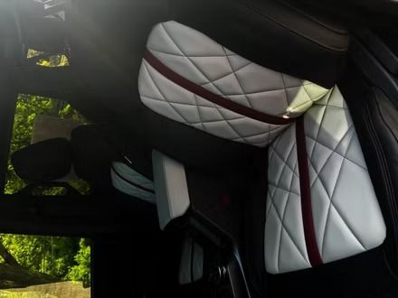 Quilted gray and white car seat cover with burgundy trim inside a vehicle