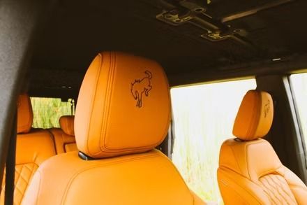 Tan leather car seats and headrests inside a vehicle interior with a sunroof opening