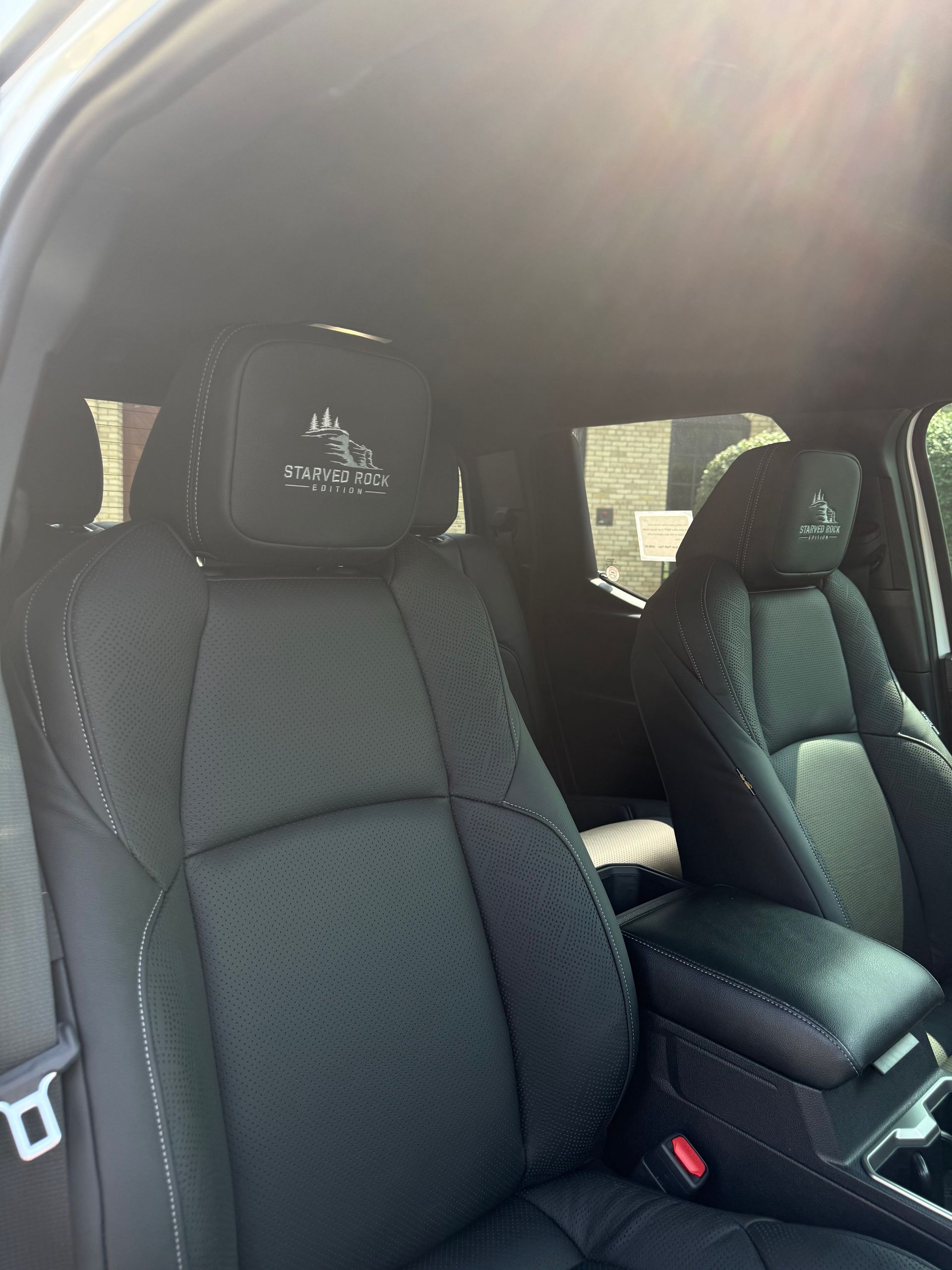 Interior of a car with black leather bucket seats and visible headrests, front passenger side view