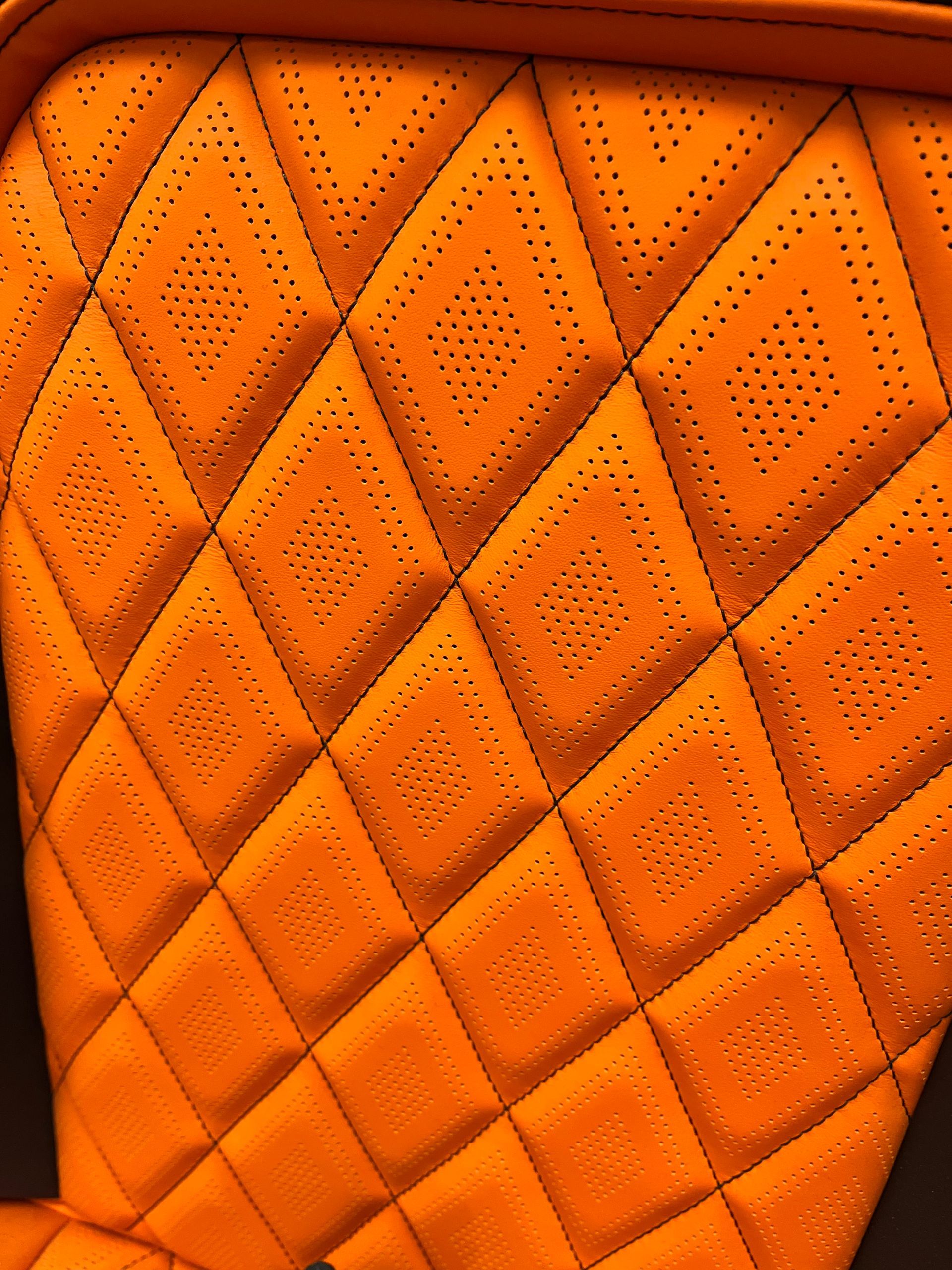 Orange quilted leather texture with diamond stitching and dotted perforations