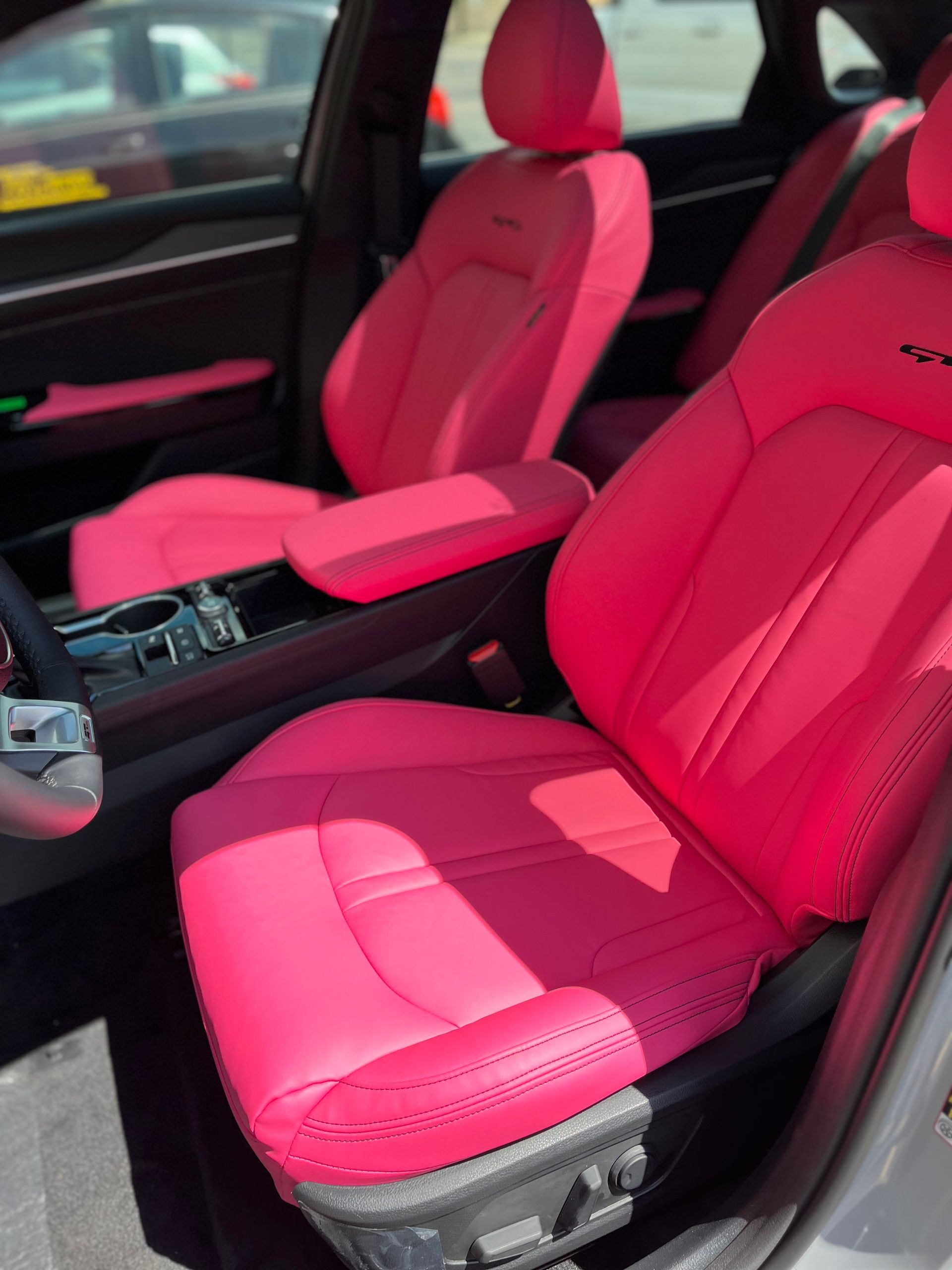Bright pink car interior with pink front seats and center console