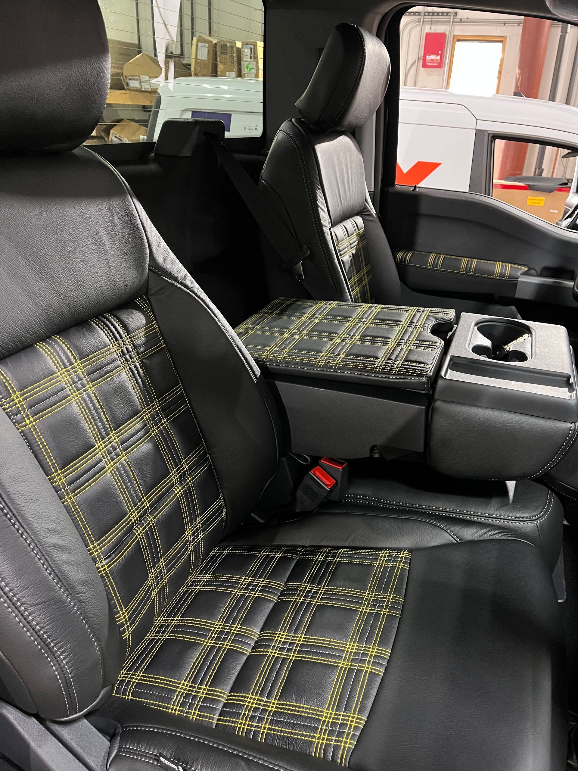 Black car seats with yellow plaid inserts in a vehicle interior