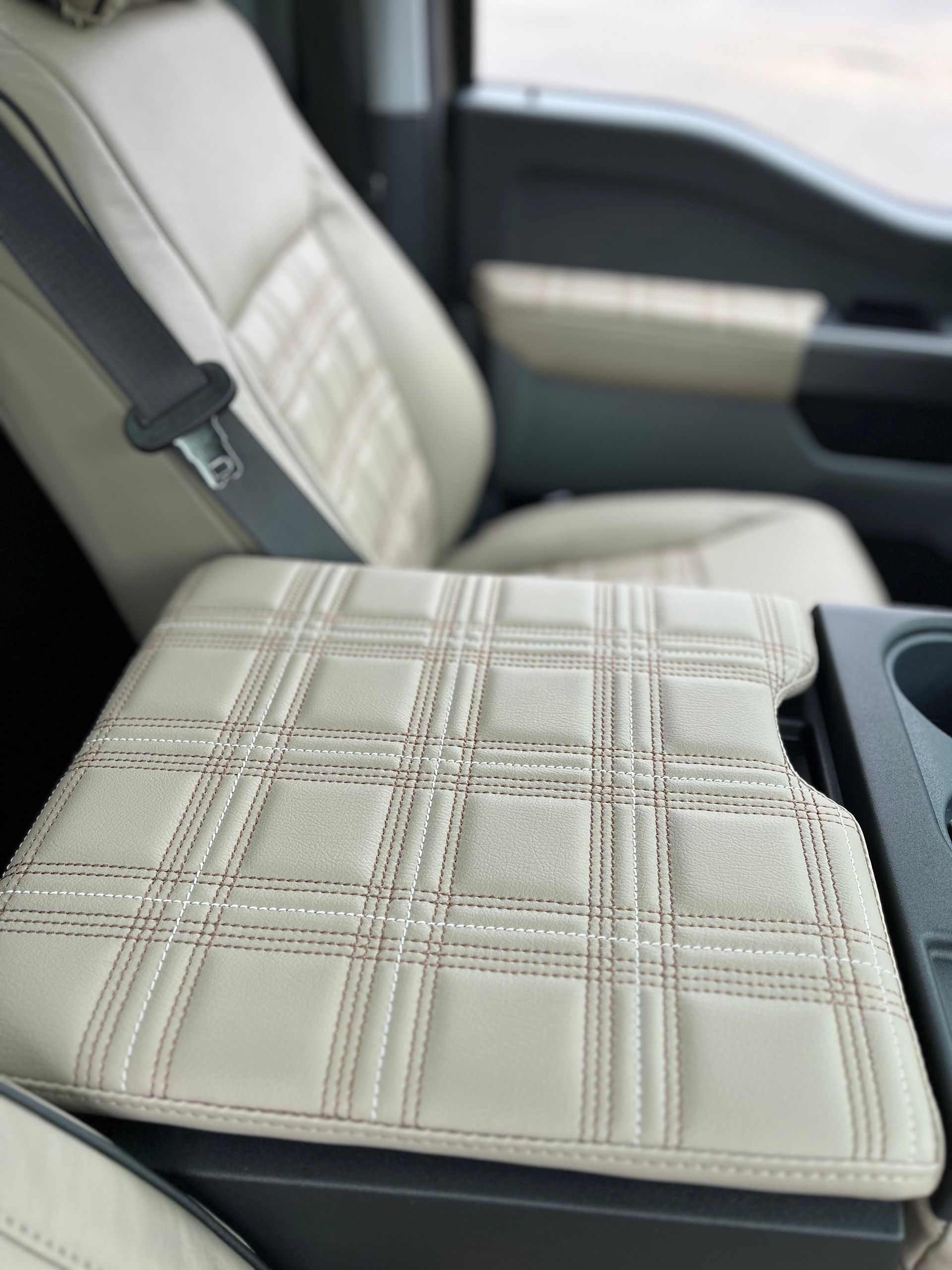 Beige quilted seat cushion on a car seat interior