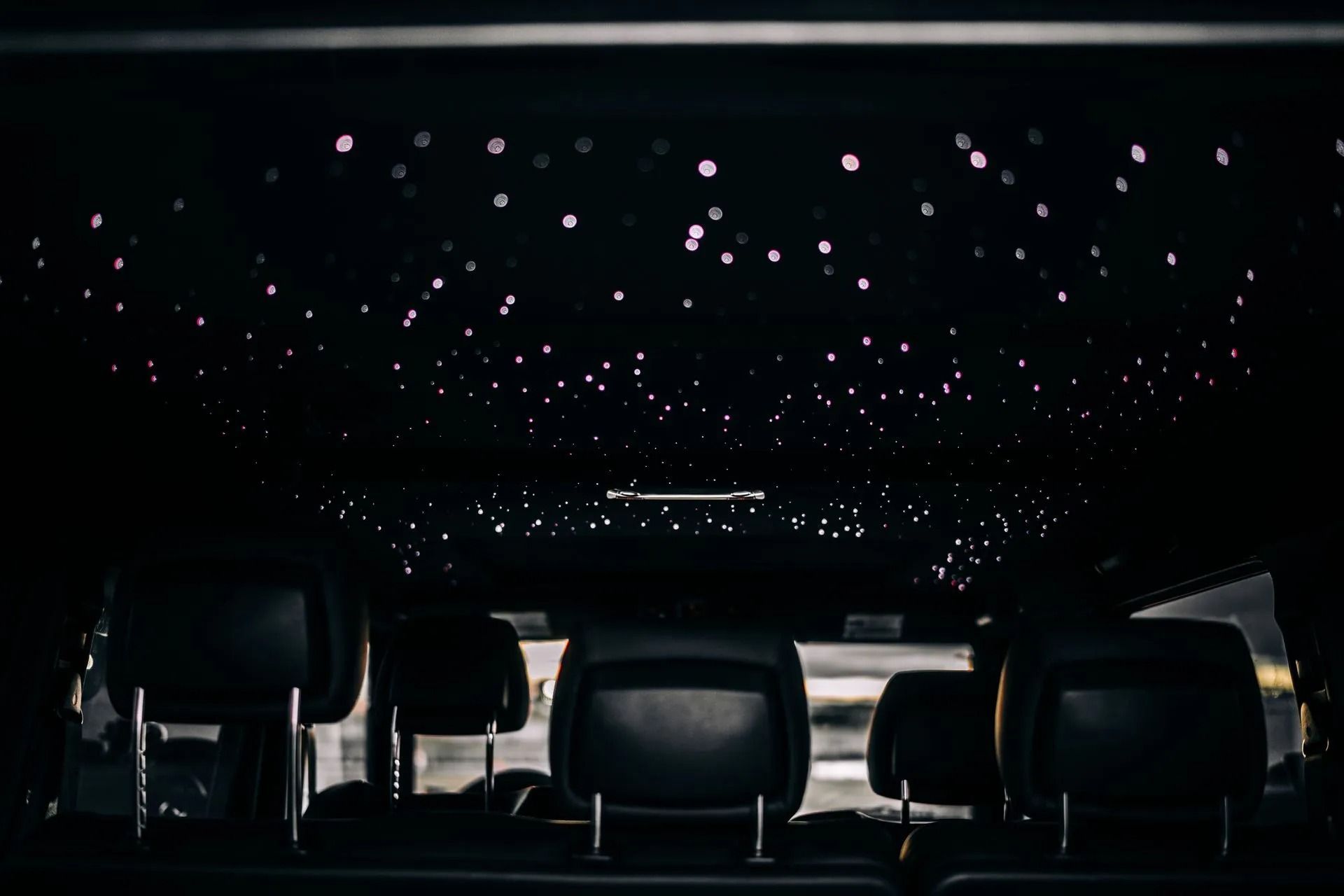 Empty theater with rows of seats under a dark ceiling lit by many small star-like lights