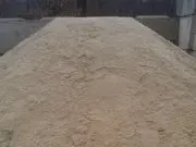 A large pile of sand is sitting on the ground.
