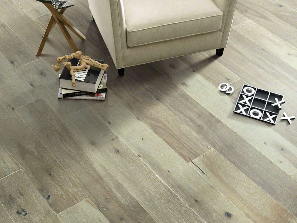 Wood flooring with chair, books, toy horse, tic-tac-toe game in a bright setting.