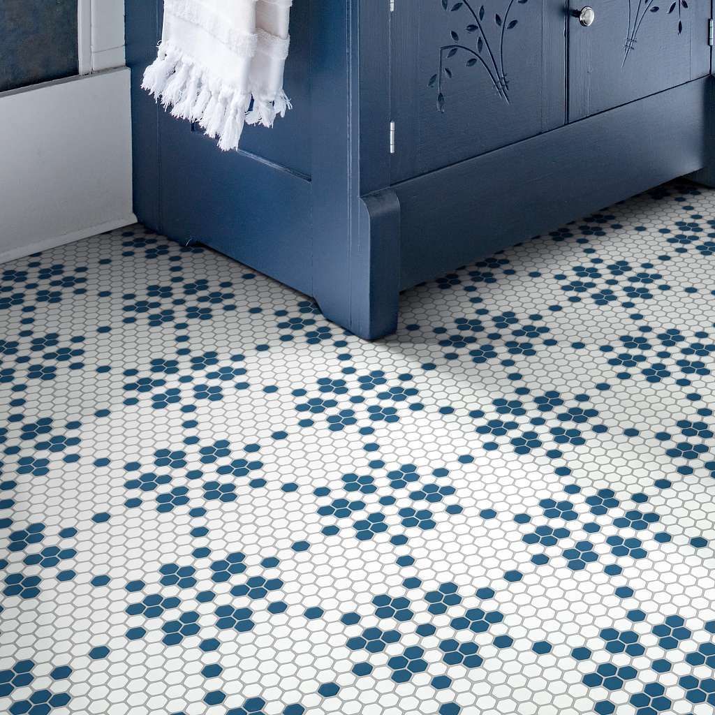 Blue floral tile floor under a navy blue cabinet with a white towel.