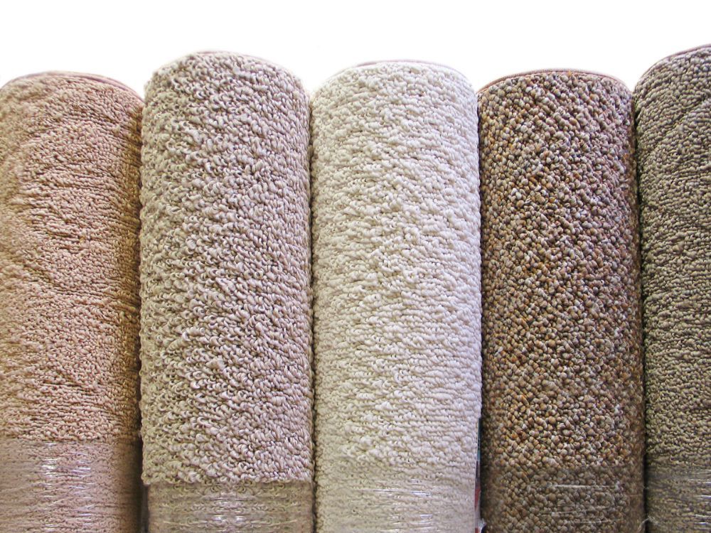 Five spools of textured yarn in varying neutral colors.