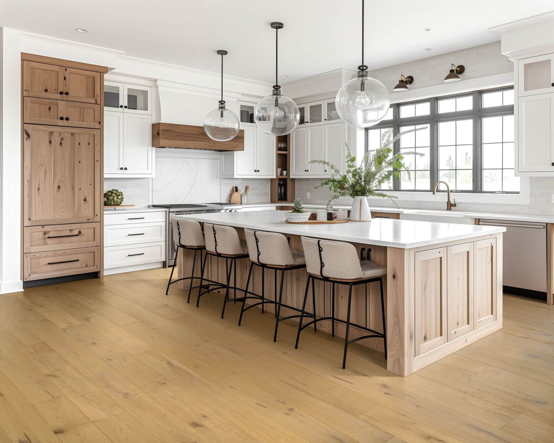 Bright kitchen with white and wood cabinets, island with stools, and light wood flooring.