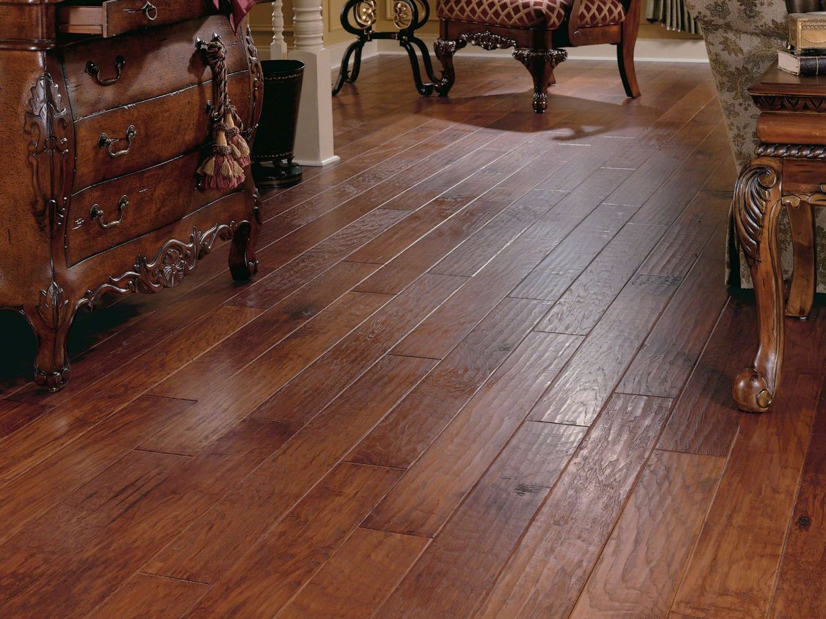 Polished hardwood floor, rich brown, reflecting light. Antique furniture in background.
