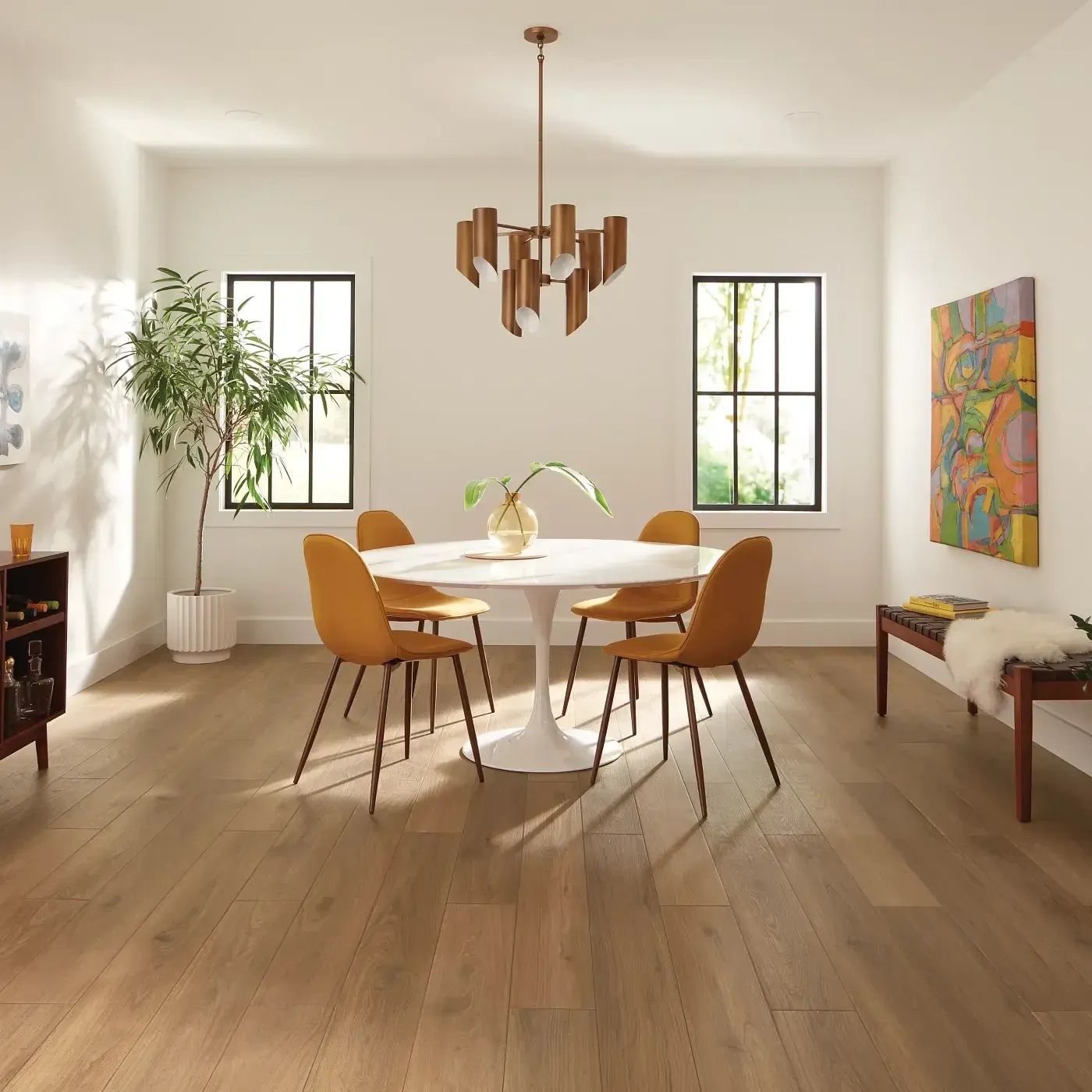 Dining room with round white table, yellow chairs, and wood flooring.