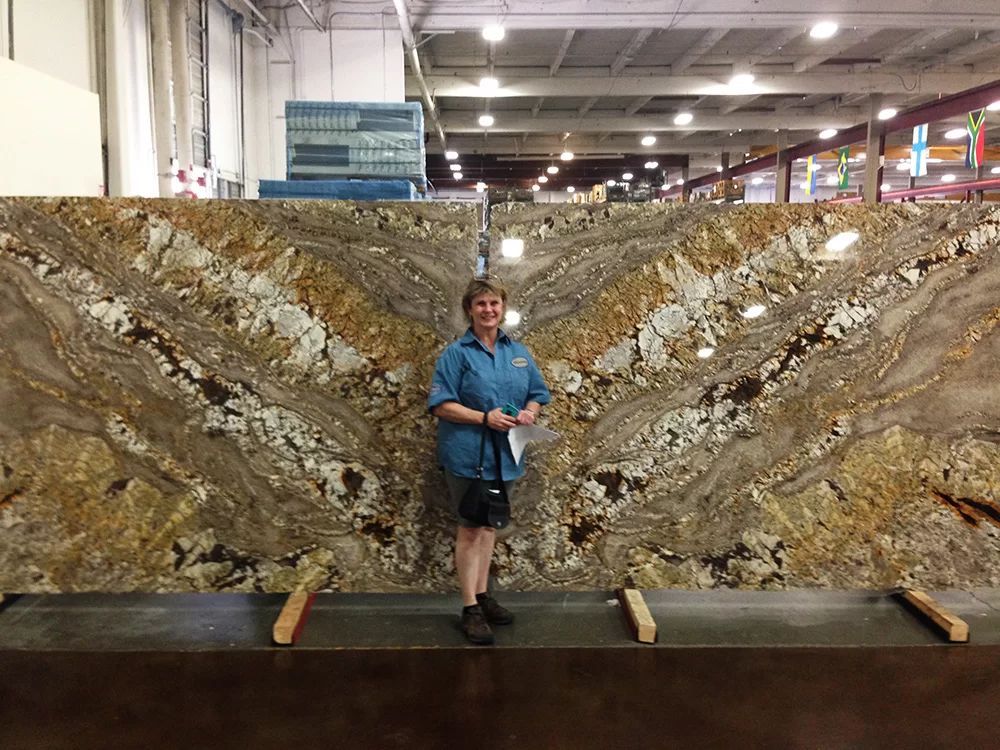 Person standing before a large sliced rock display in a museum exhibit