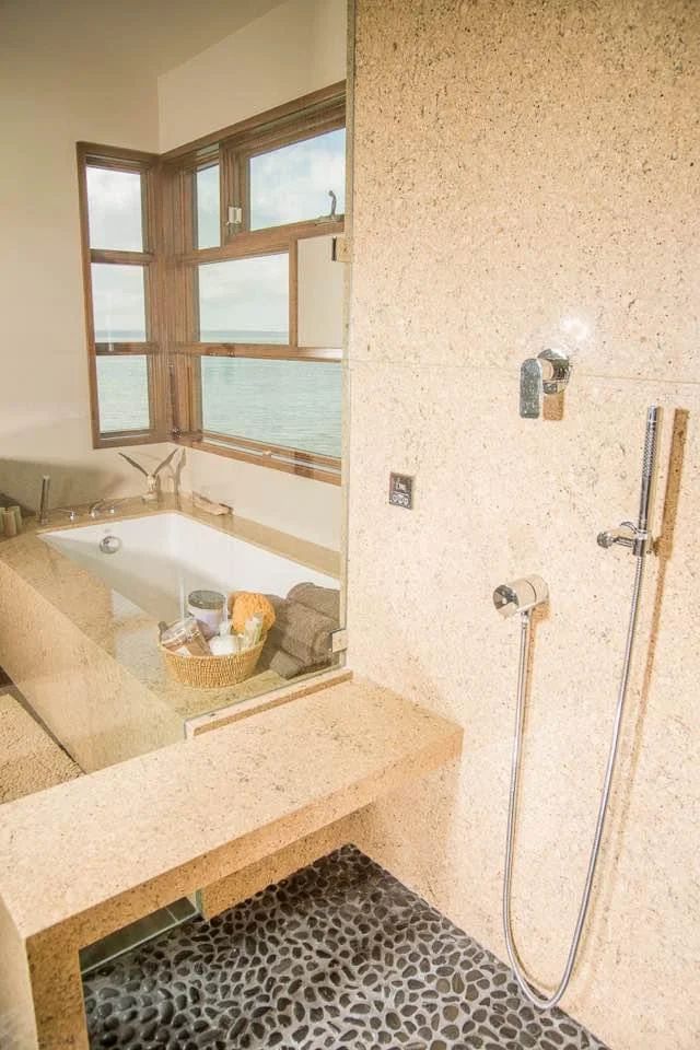 Modern bathroom with a freestanding tub, window, and pebble-pattern shower floor