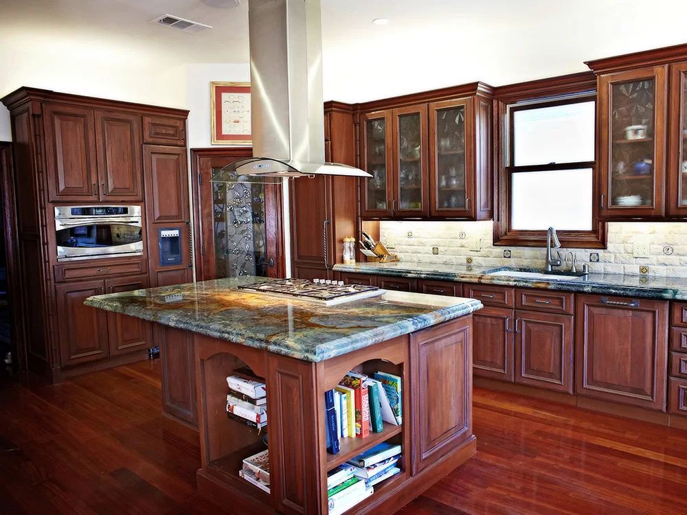 Modern kitchen with dark wood cabinets, granite island, and polished hardwood floors