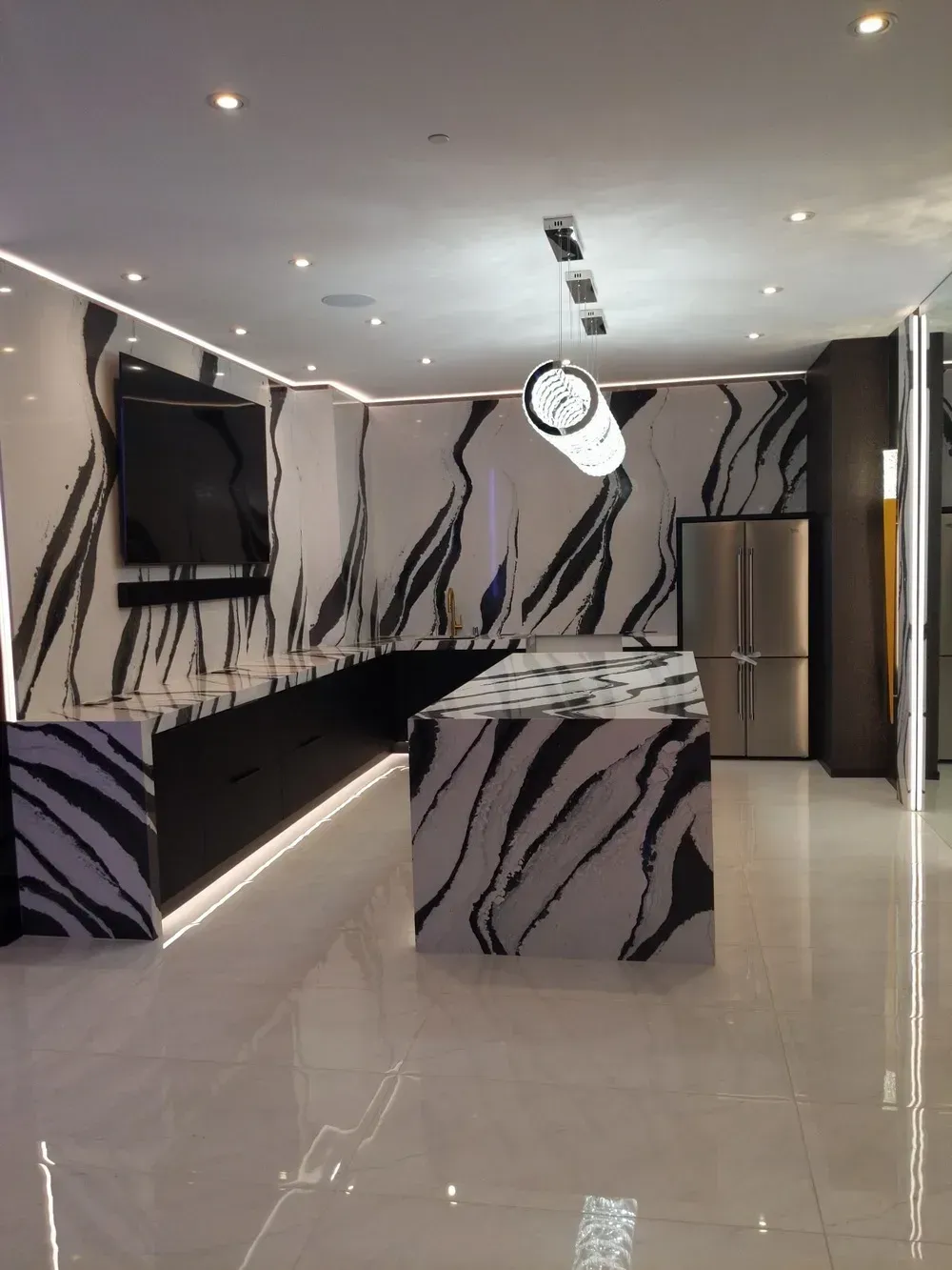 Modern lobby with zebra-patterned walls, glossy tile floor, wall TV, clock, and metallic reception desk.
