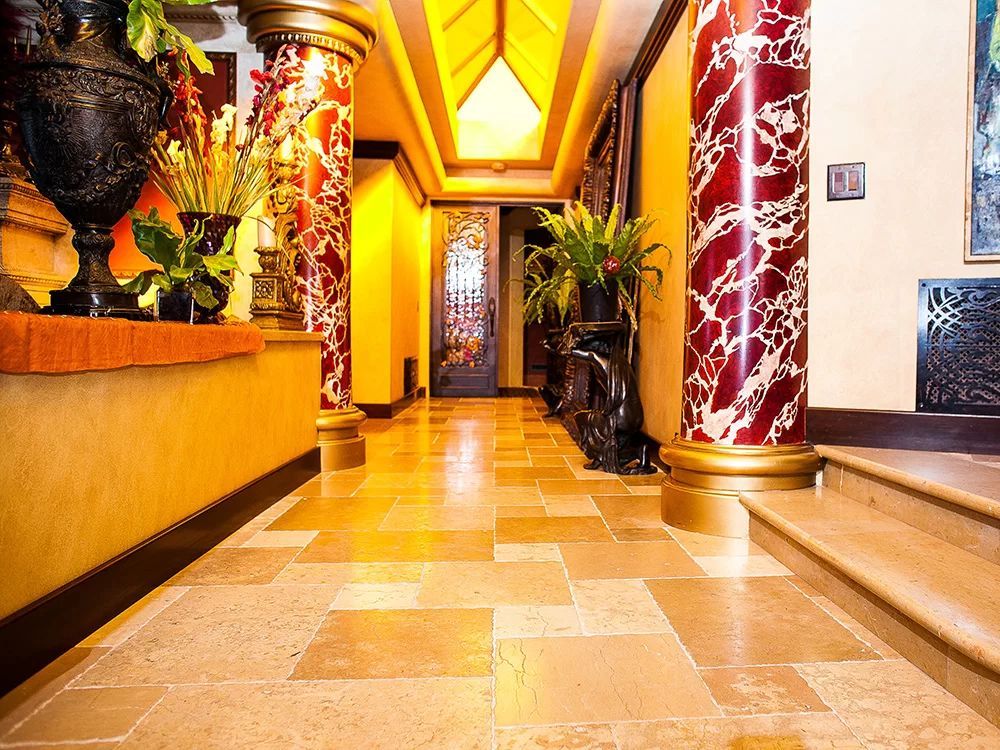 Elegant hotel lobby with red marble columns, warm lighting, and polished tile floor