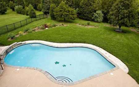 An aerial view of a large swimming pool in a backyard