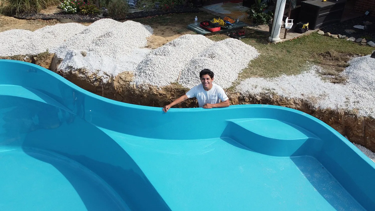 A man is standing on the edge of a swimming pool.
