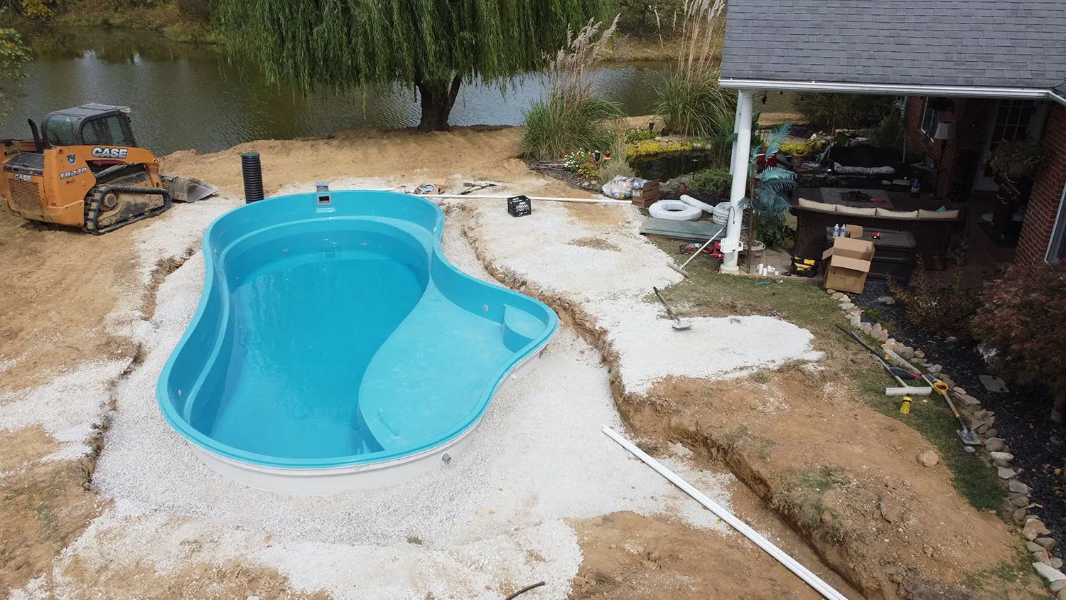 An aerial view of a swimming pool being built in a backyard.