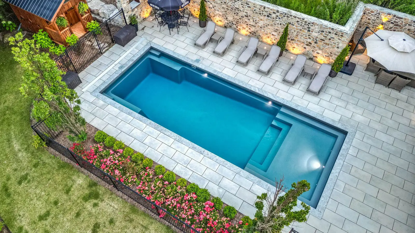 An aerial view of a large swimming pool in a backyard.