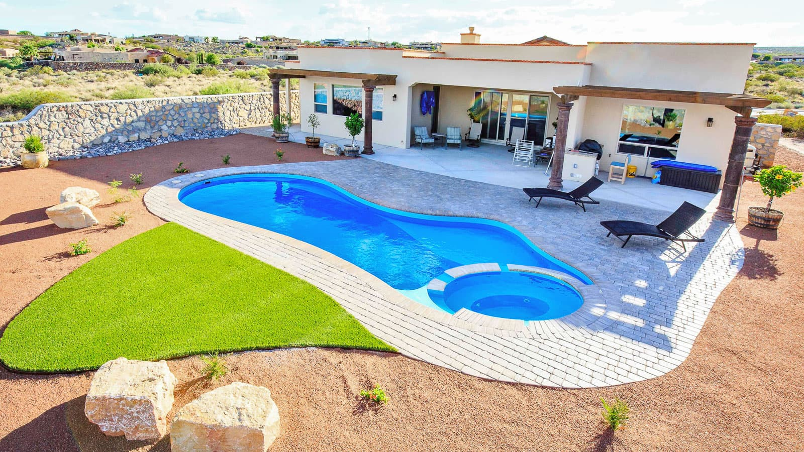 An aerial view of a house with a large swimming pool in the backyard.