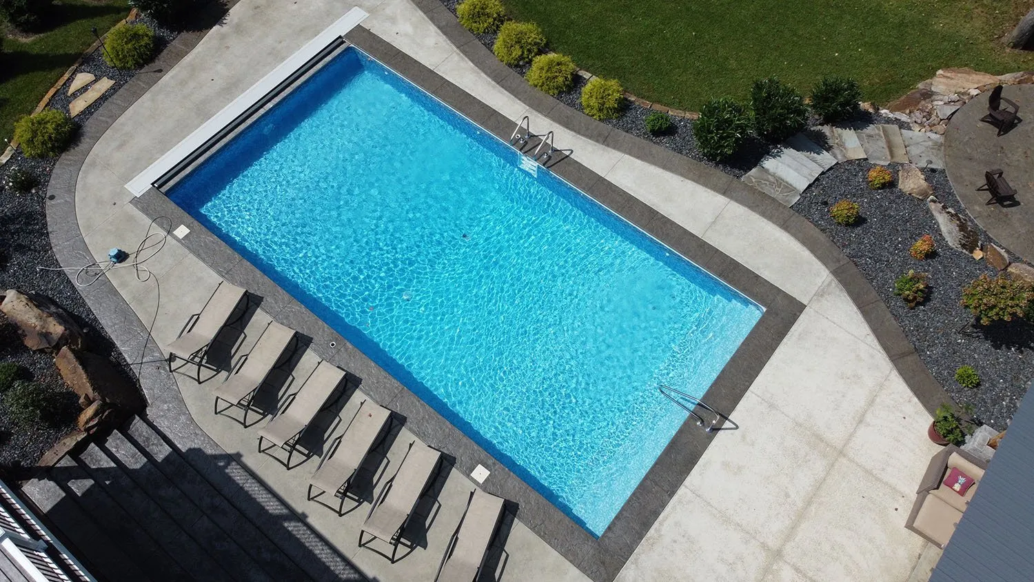 An aerial view of a large swimming pool surrounded by lawn chairs.