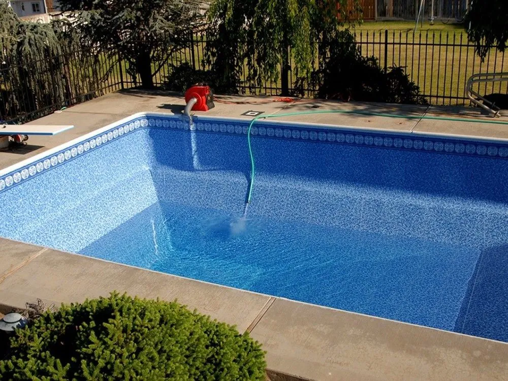 A large swimming pool with a hose attached to it