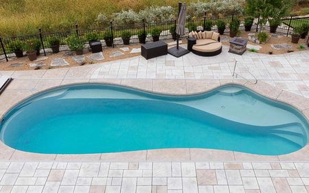 An aerial view of a large swimming pool surrounded by patio furniture.