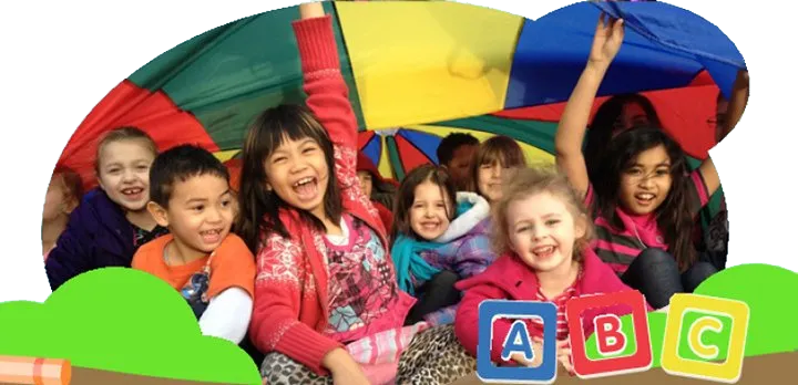 a group of children are sitting under an umbrella with abc blocks in the background