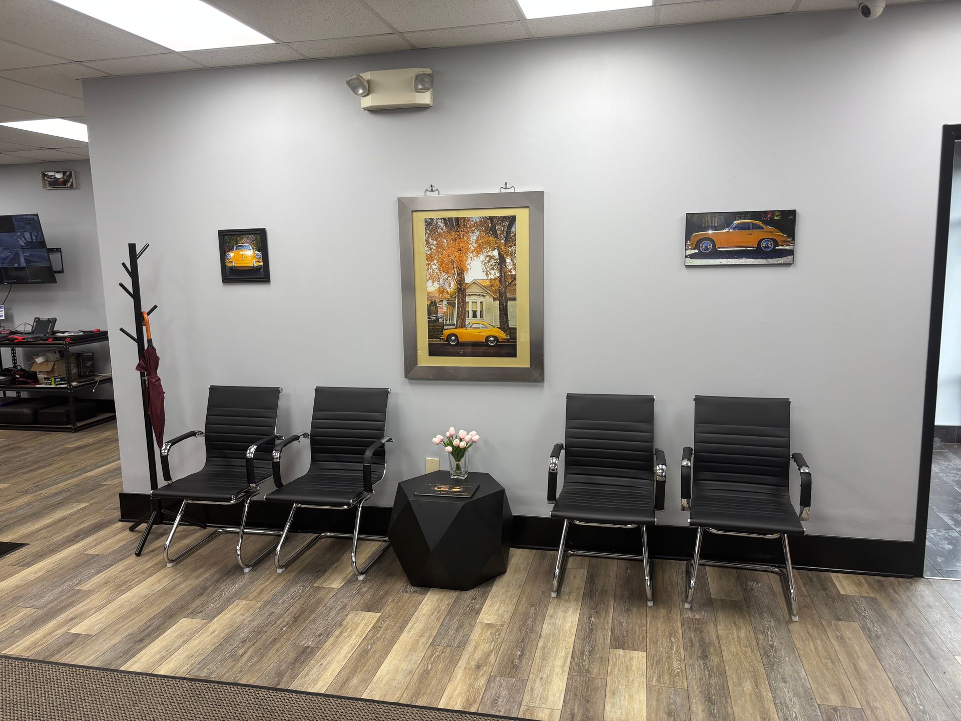A waiting room with chairs , a table and a picture on the wall.