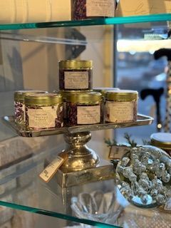 A display of jars on a glass shelf in a store.