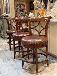 A row of bar stools are sitting next to each other in a kitchen.
