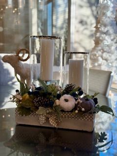 A table with a vase of flowers and candles on it.