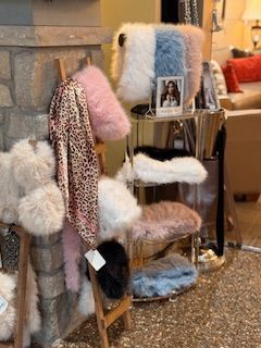 A display of furry pillows and blankets in a living room.
